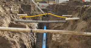 excavated trench with multiple criss-crossing pipes